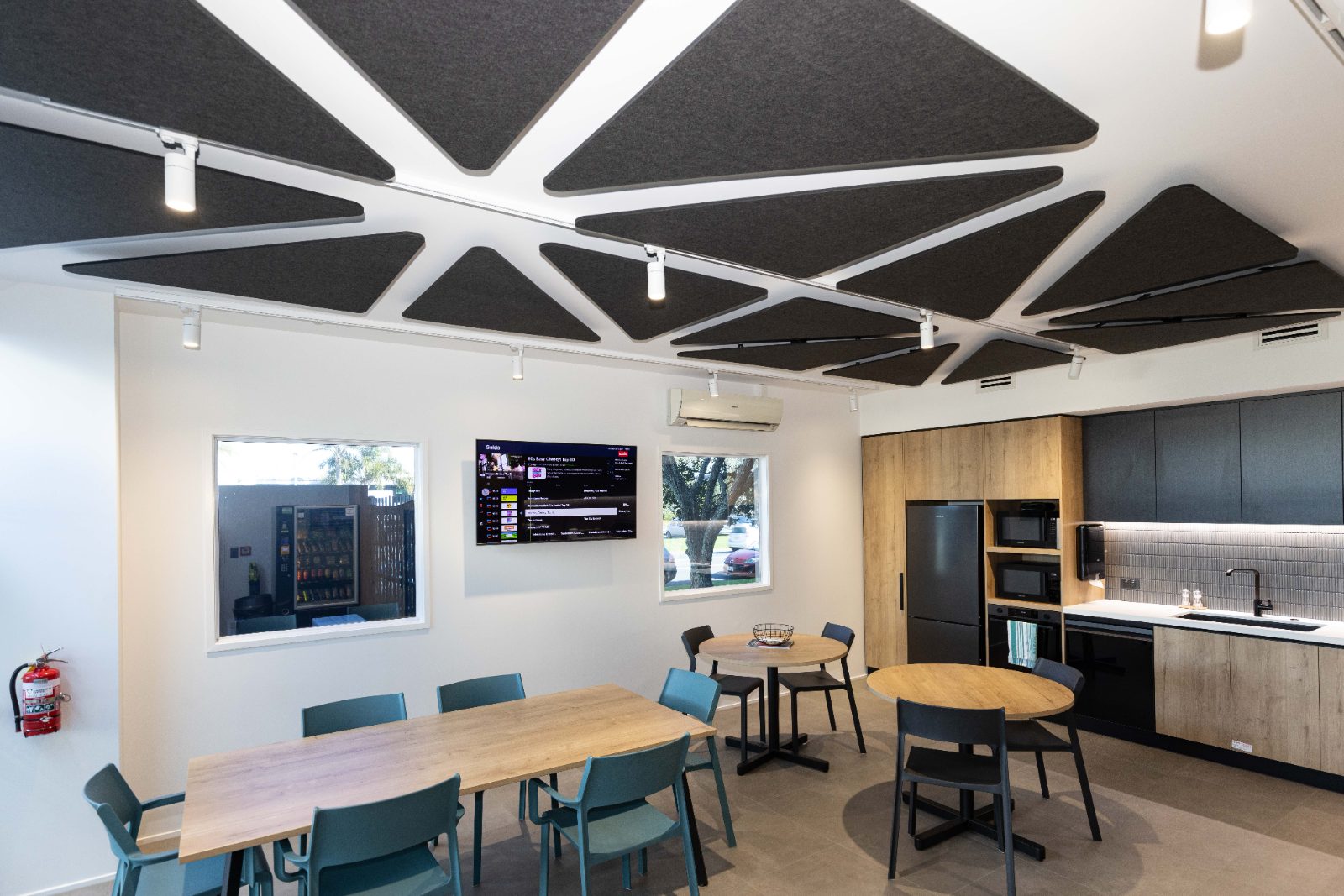 Staff kitchen and dining table under triangular acoustic ceiling panels